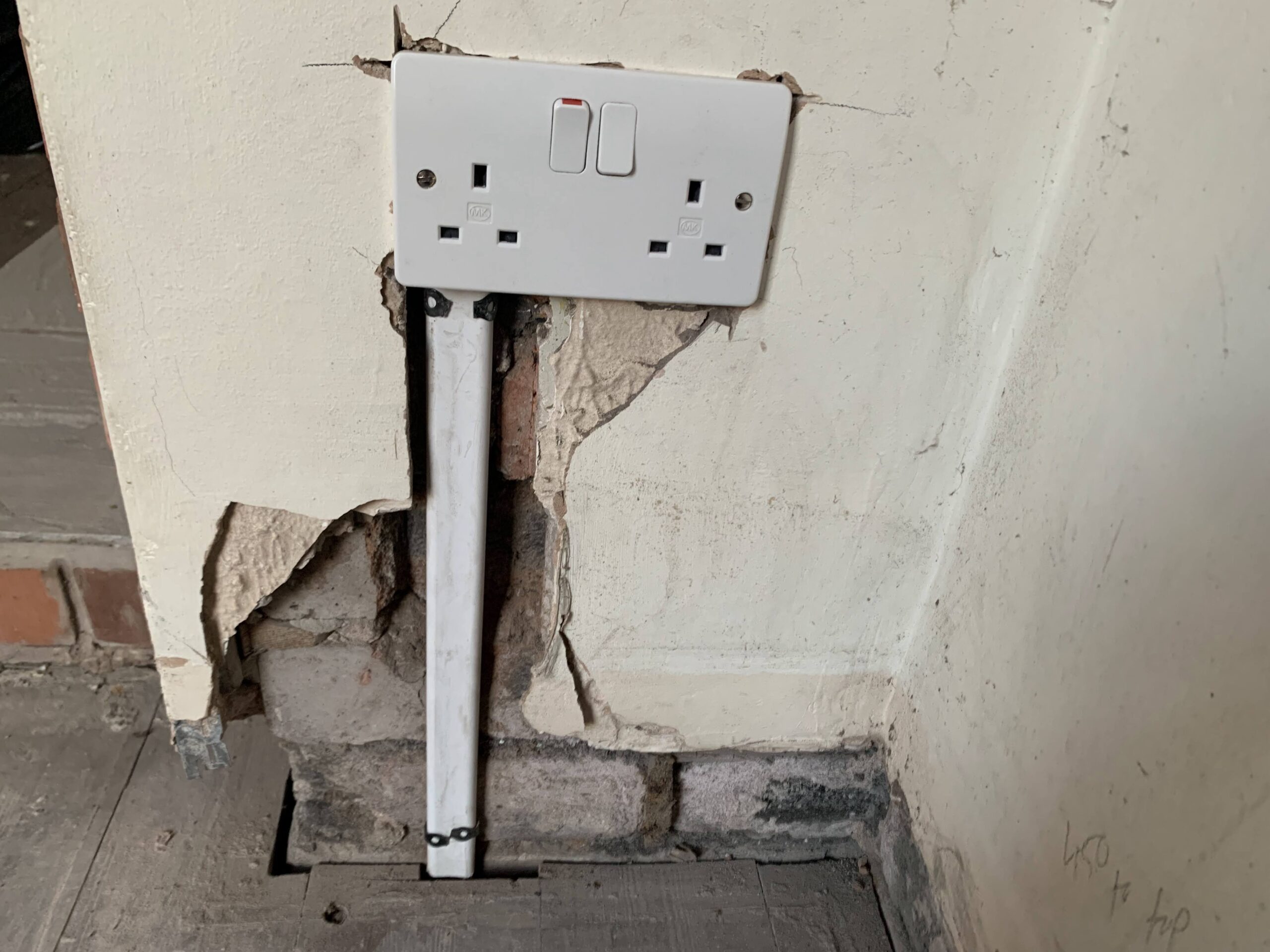 A newly installed outdoor electrical socket on a brick wall.